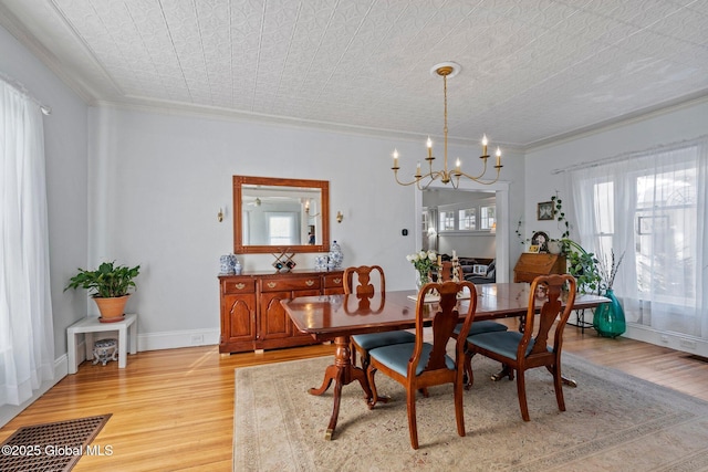 dining room with ornamental molding, a chandelier, and light hardwood / wood-style floors