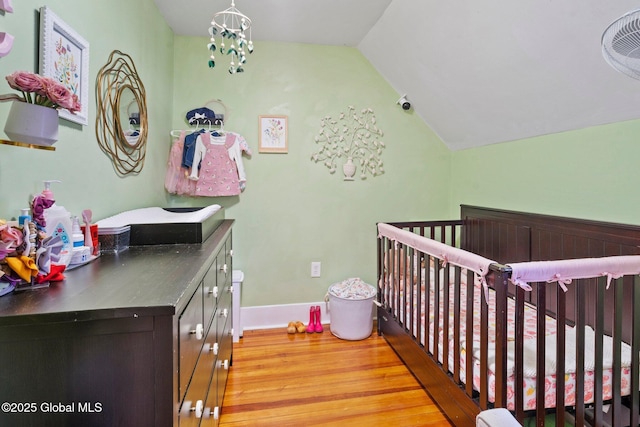 bedroom featuring lofted ceiling, a chandelier, and light hardwood / wood-style flooring