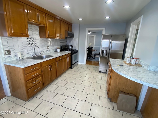 kitchen with tasteful backsplash, light tile patterned flooring, appliances with stainless steel finishes, and sink