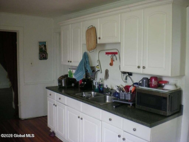 kitchen with white cabinetry, sink, and dark hardwood / wood-style floors