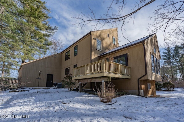 snow covered property with a wooden deck