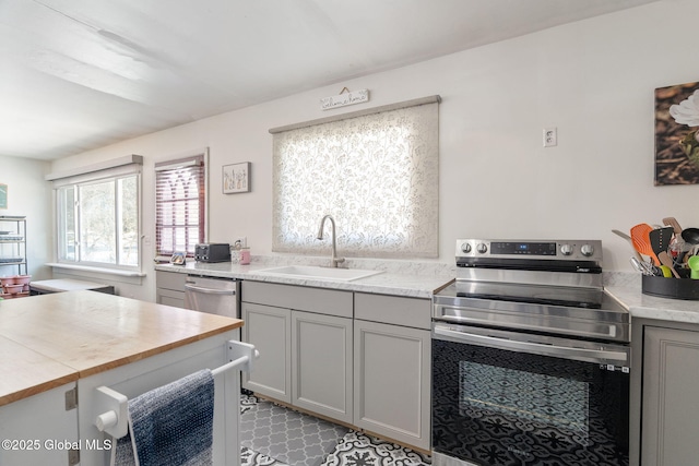 kitchen with gray cabinetry, sink, and stainless steel appliances