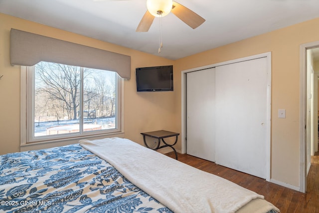 bedroom featuring ceiling fan, dark hardwood / wood-style floors, vaulted ceiling, and a closet