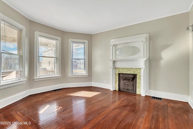 unfurnished living room featuring a tile fireplace and wood-type flooring