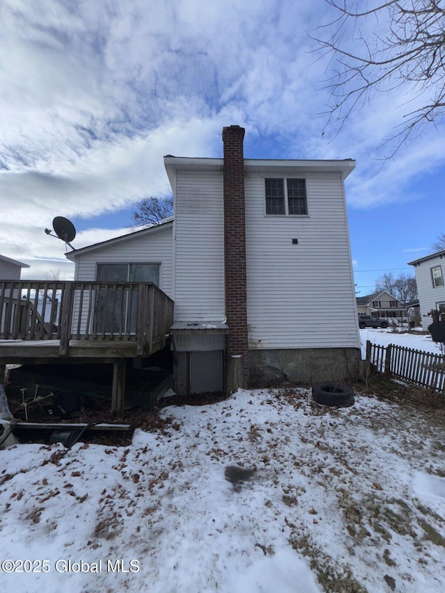 snow covered house with a wooden deck