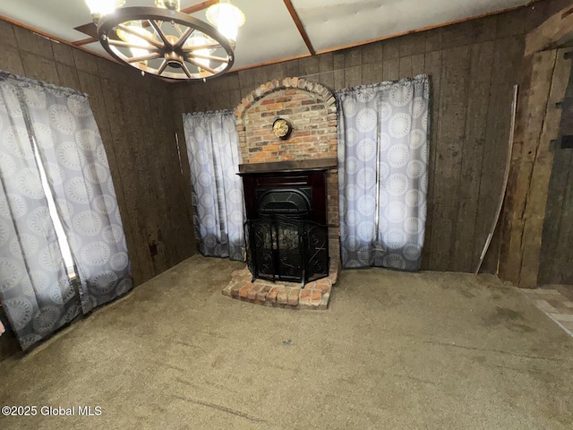 unfurnished living room featuring wood walls and carpet