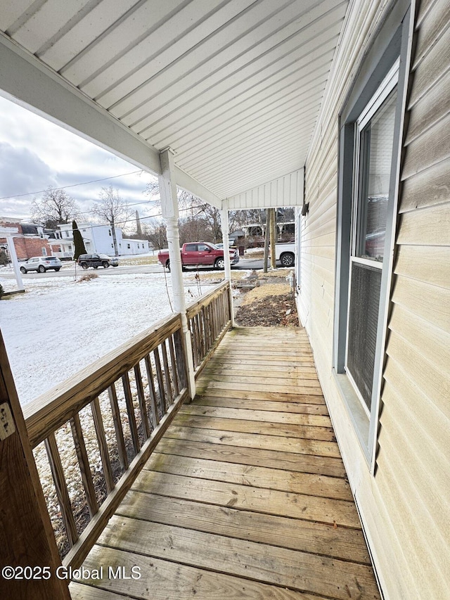 snow covered deck featuring a porch