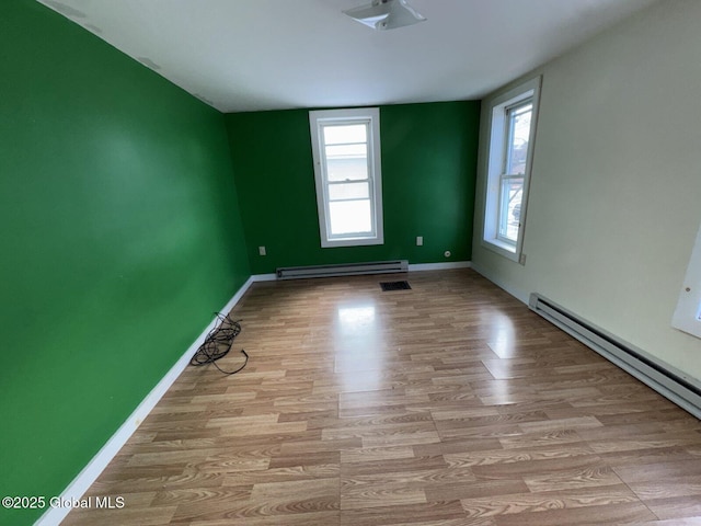 spare room featuring light hardwood / wood-style floors and a baseboard heating unit