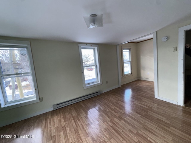 spare room with wood-type flooring and baseboard heating