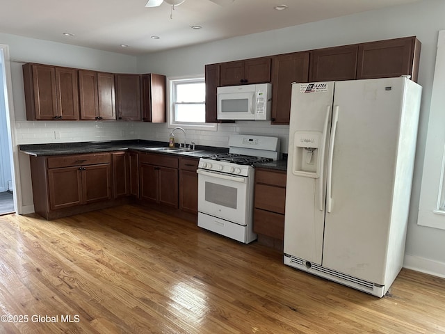 kitchen featuring white appliances, sink, light hardwood / wood-style flooring, and backsplash