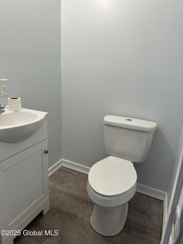 bathroom featuring vanity, hardwood / wood-style flooring, and toilet