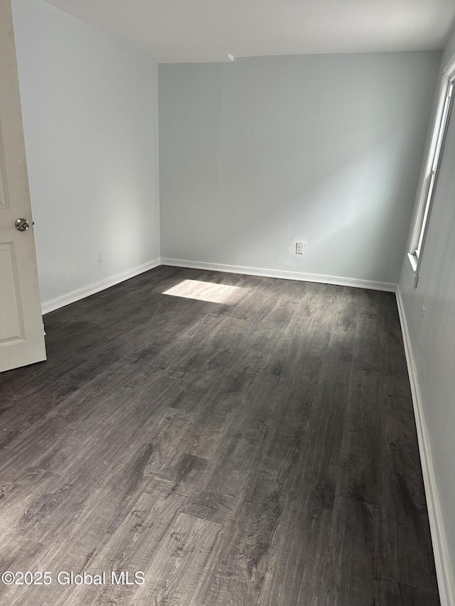 unfurnished room with dark hardwood / wood-style flooring