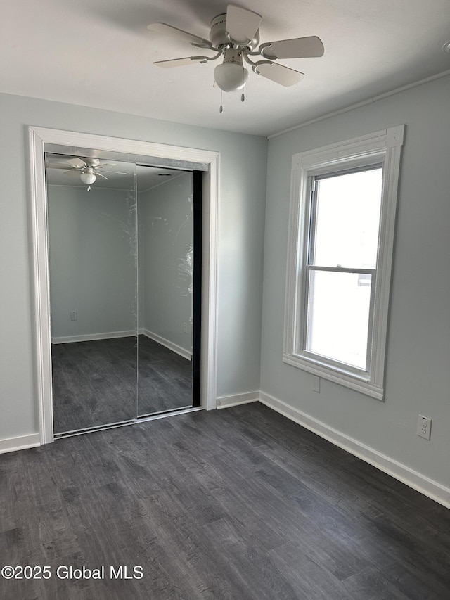 unfurnished bedroom with ceiling fan, dark hardwood / wood-style flooring, and a closet