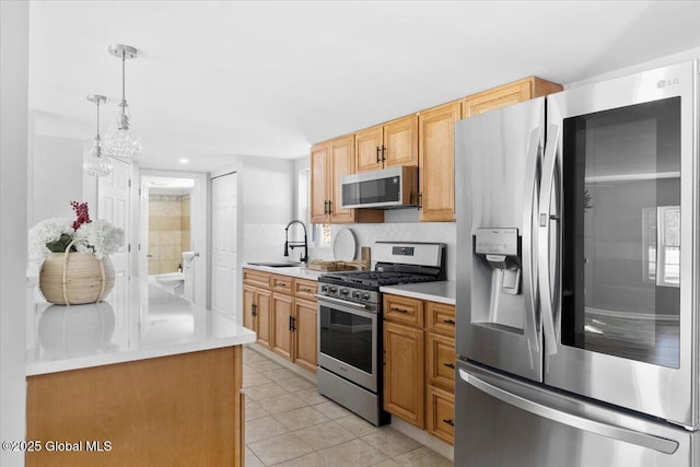 kitchen with light tile patterned floors, sink, appliances with stainless steel finishes, hanging light fixtures, and decorative backsplash