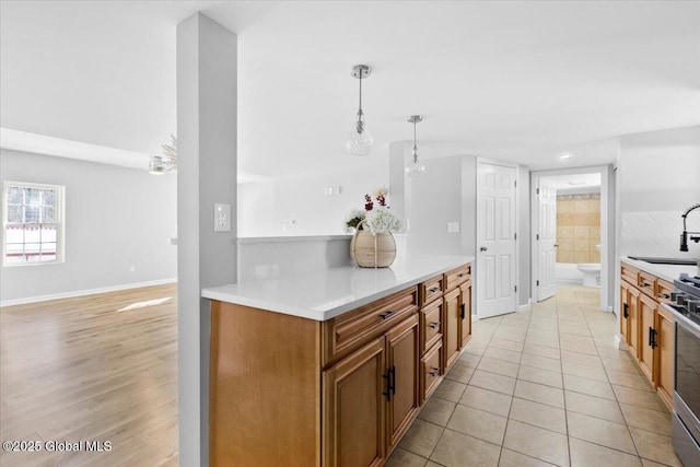 kitchen with stainless steel range, decorative light fixtures, and light tile patterned floors