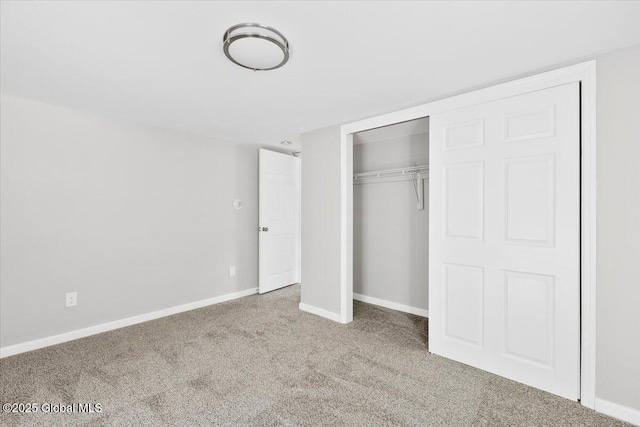 unfurnished bedroom featuring light colored carpet and a closet