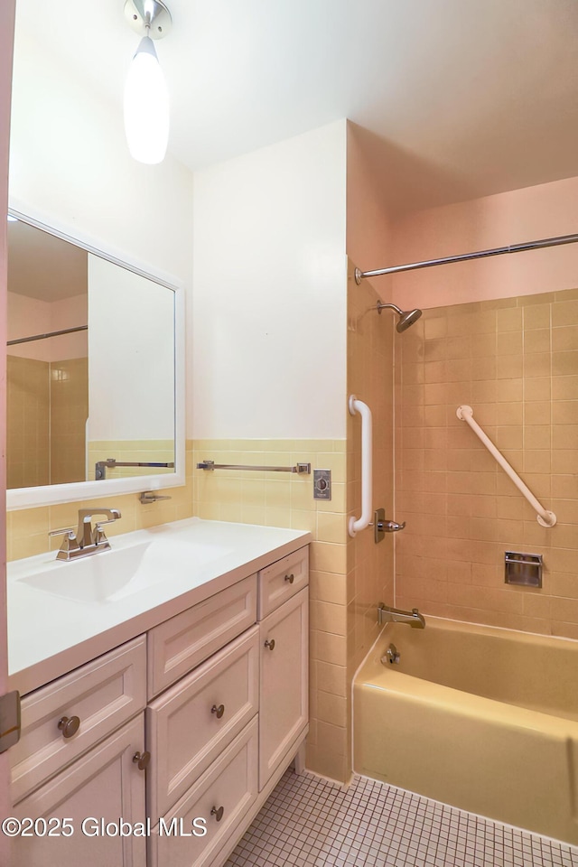 bathroom featuring vanity, tile walls, tile patterned floors, and tiled shower / bath