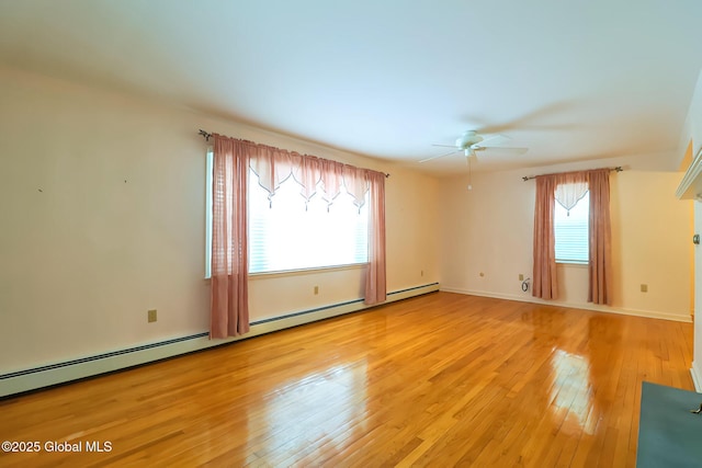 empty room featuring a baseboard heating unit, light hardwood / wood-style flooring, and ceiling fan