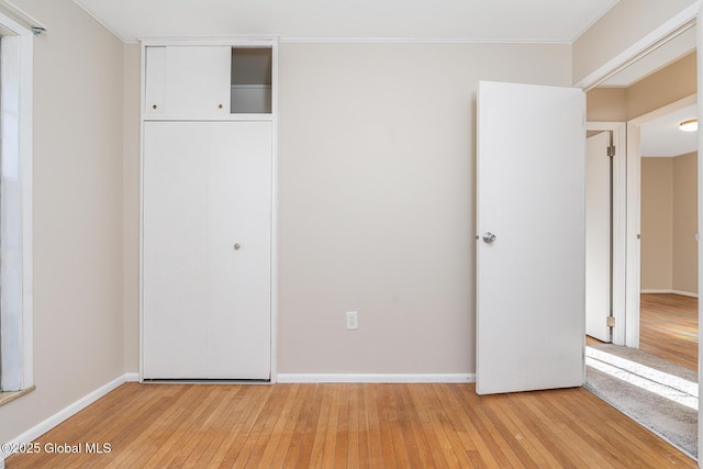 unfurnished bedroom with a closet and light wood-type flooring