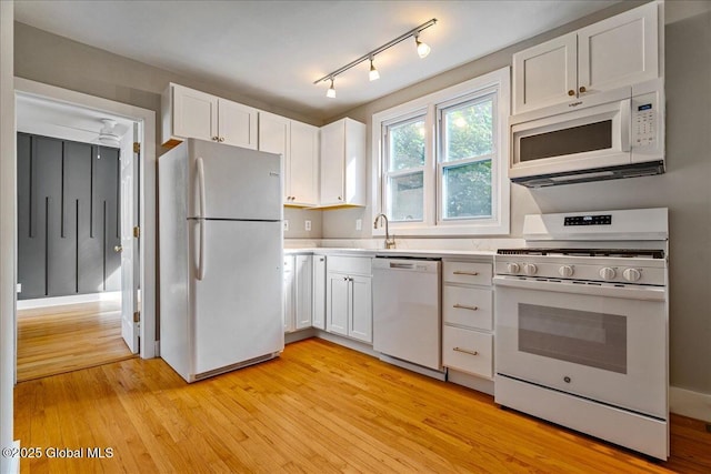 kitchen featuring sink, white appliances, rail lighting, white cabinetry, and light hardwood / wood-style floors