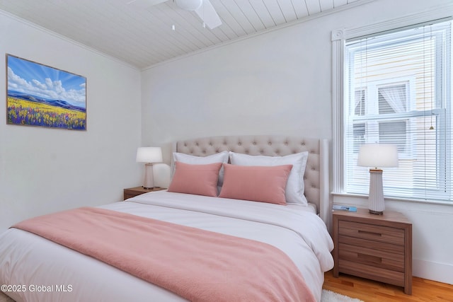 bedroom with multiple windows, wood ceiling, ornamental molding, and light hardwood / wood-style floors