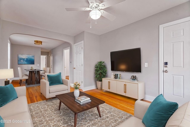 living room with light hardwood / wood-style floors and ceiling fan