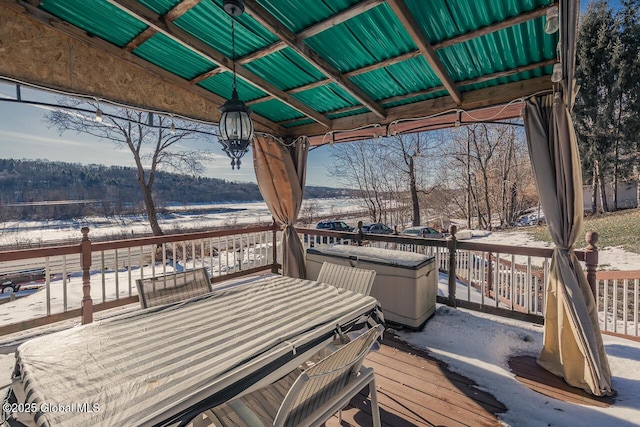 snow covered deck featuring a hot tub