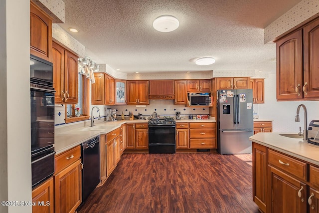 kitchen featuring sink, a textured ceiling, dark hardwood / wood-style floors, and black appliances