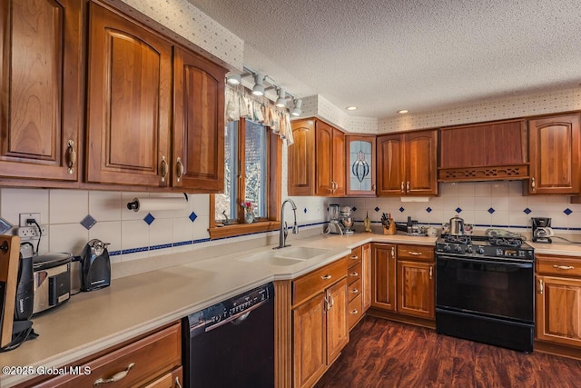 kitchen with dark hardwood / wood-style flooring, sink, a textured ceiling, and black appliances