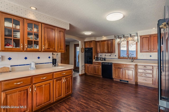 kitchen with tasteful backsplash, dark hardwood / wood-style flooring, sink, and black appliances