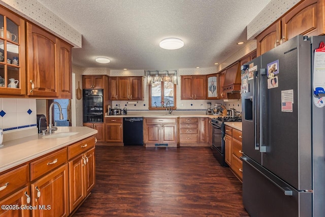 kitchen with sink, black appliances, dark hardwood / wood-style floors, and a textured ceiling