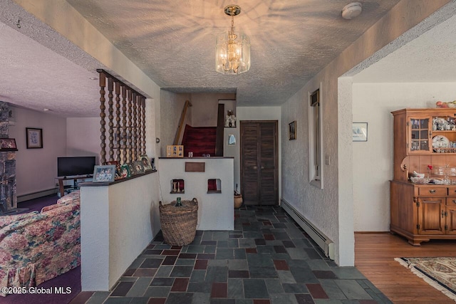 corridor featuring dark wood-type flooring, a notable chandelier, a textured ceiling, and a baseboard heating unit