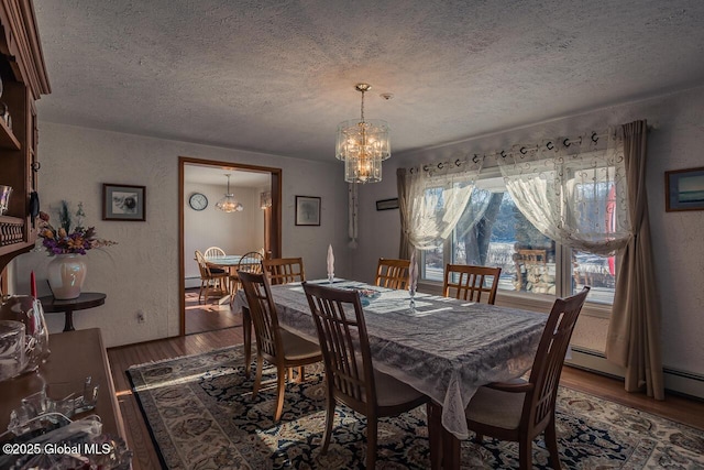 dining area featuring dark hardwood / wood-style floors, a textured ceiling, and an inviting chandelier