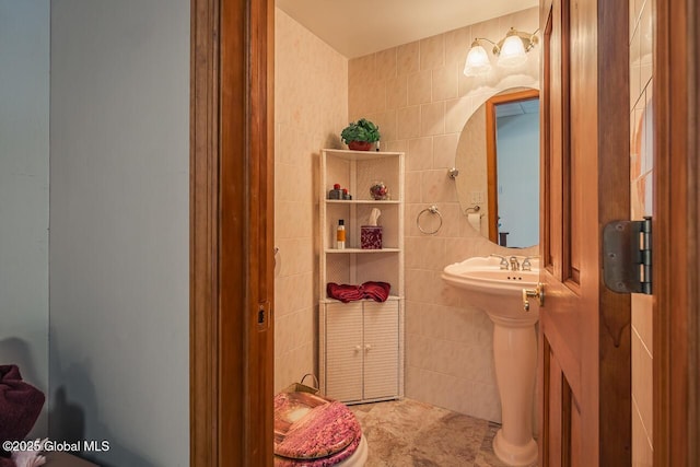 bathroom with tile walls and toilet