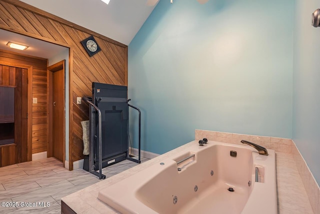 bathroom featuring wooden walls and a bath