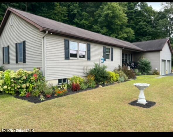 ranch-style home featuring a front lawn and an attached garage