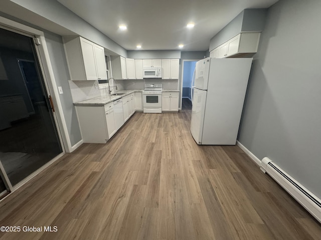 kitchen featuring sink, white appliances, white cabinetry, light stone countertops, and a baseboard radiator