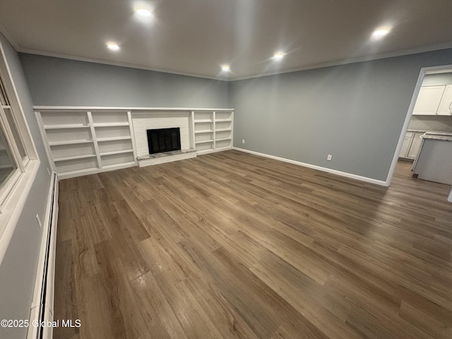 unfurnished living room featuring crown molding, dark hardwood / wood-style floors, a fireplace, and a baseboard radiator