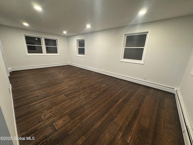 empty room featuring dark wood-type flooring and a baseboard radiator