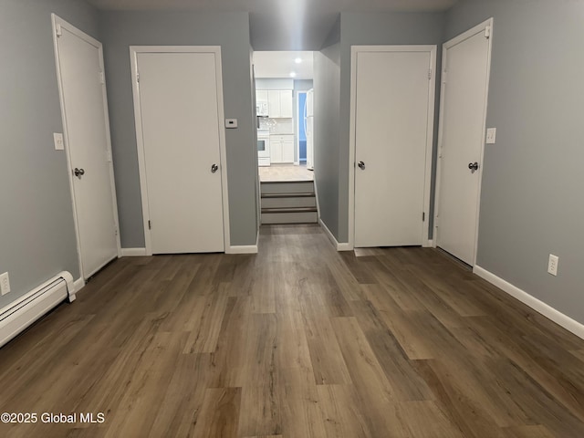 empty room with wood-type flooring and a baseboard radiator