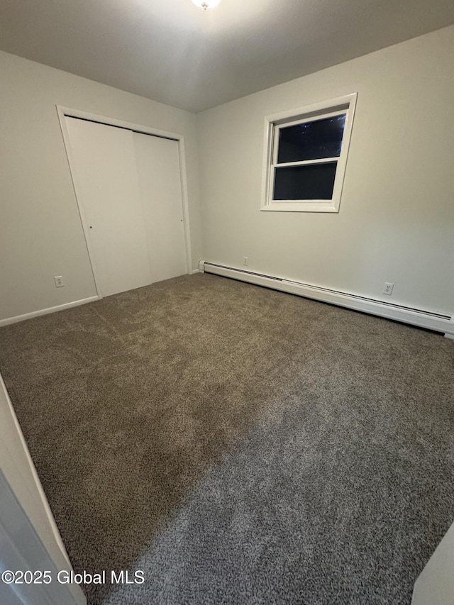 unfurnished bedroom with carpet floors, a baseboard radiator, and a closet