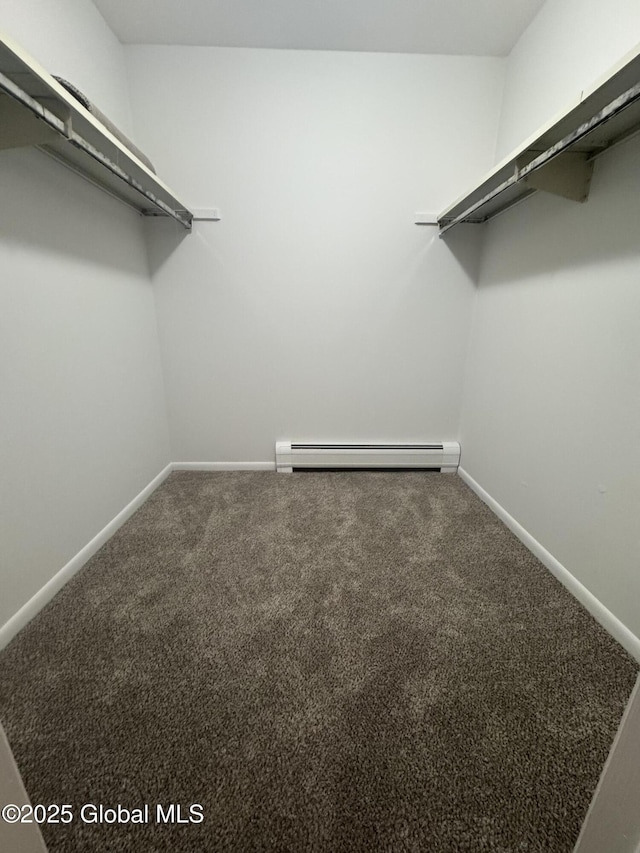 walk in closet featuring a baseboard heating unit and carpet floors