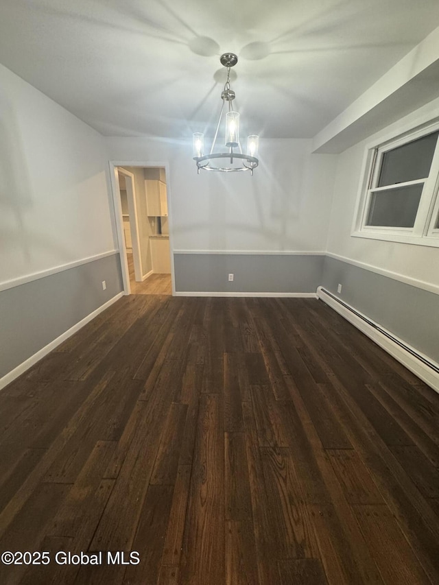 unfurnished dining area featuring an inviting chandelier, dark hardwood / wood-style flooring, and a baseboard heating unit