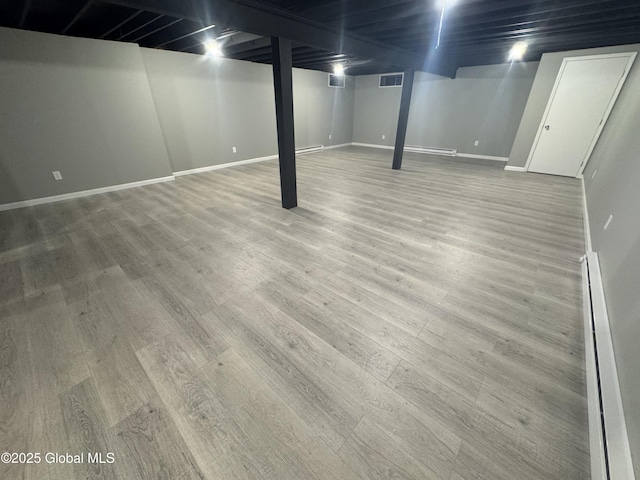 basement with light hardwood / wood-style flooring