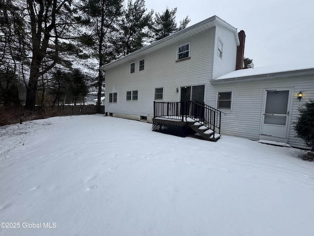 view of snow covered back of property