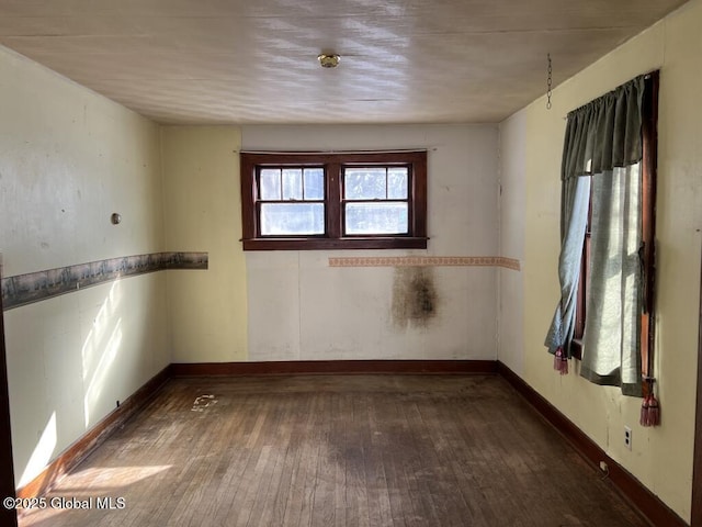 unfurnished room with dark hardwood / wood-style flooring