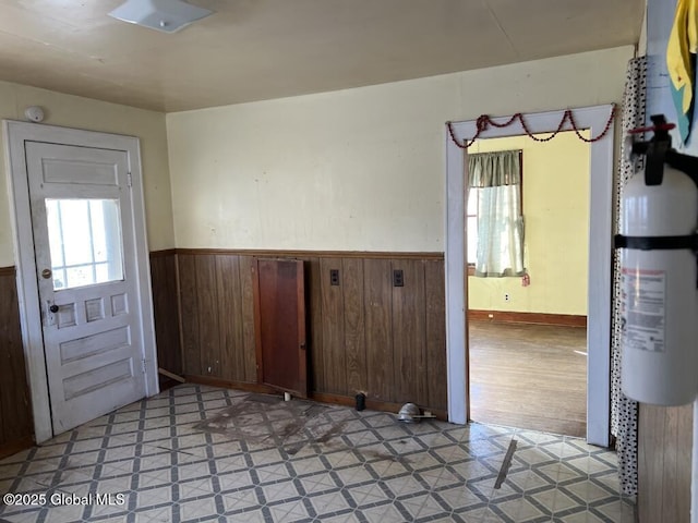 unfurnished room featuring wooden walls