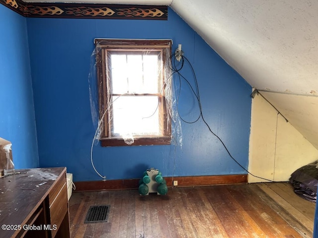 bonus room with dark hardwood / wood-style floors and vaulted ceiling