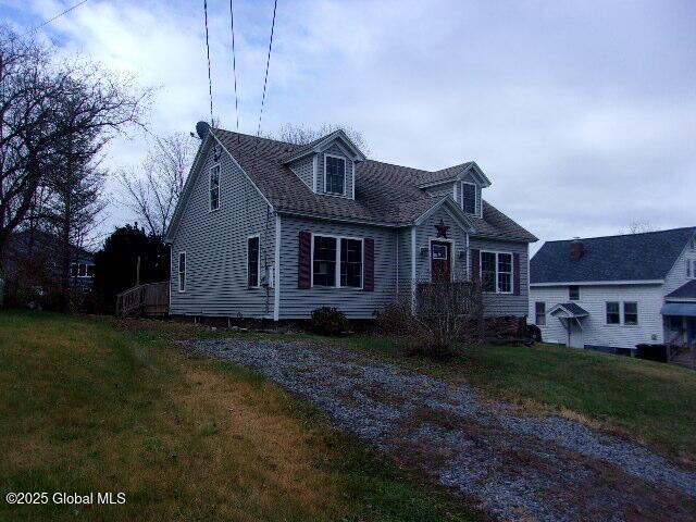 cape cod home with a front lawn