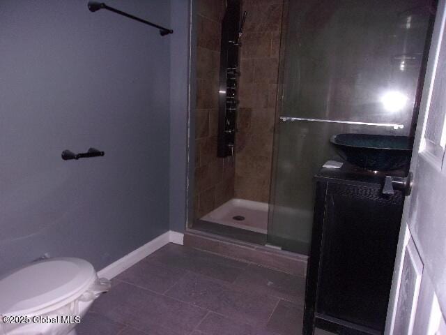 bathroom with toilet, tile patterned flooring, and a shower with door
